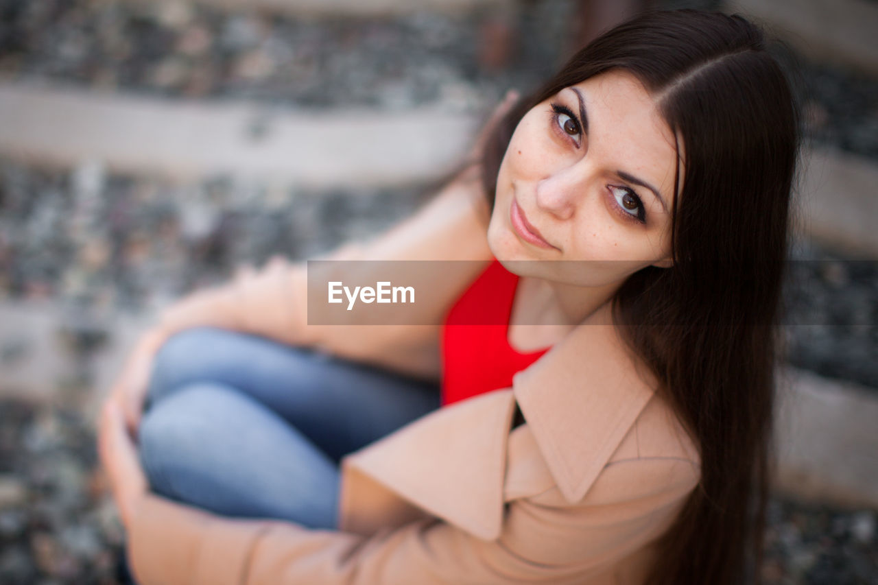 High angle portrait of woman sitting outdoors