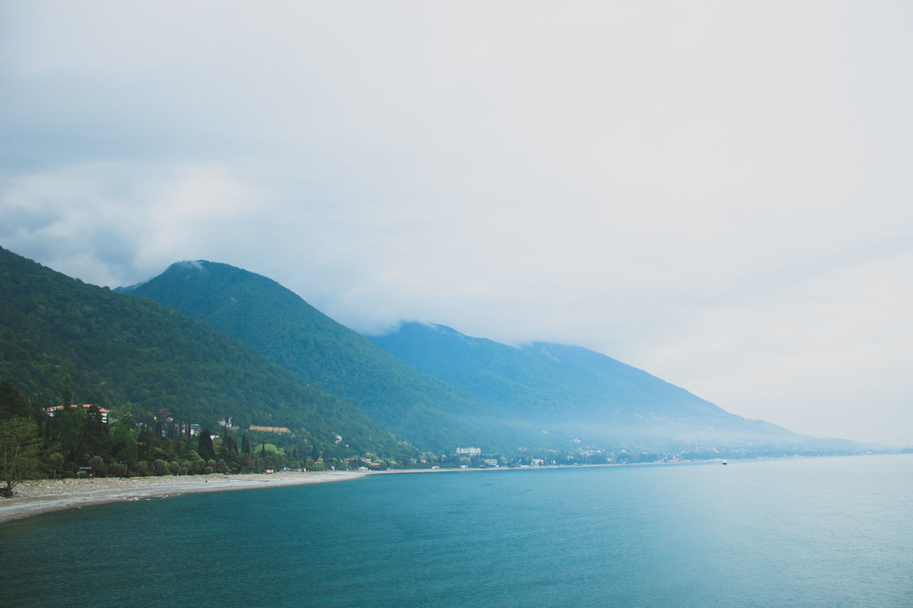 Scenic view of sea and mountains against sky