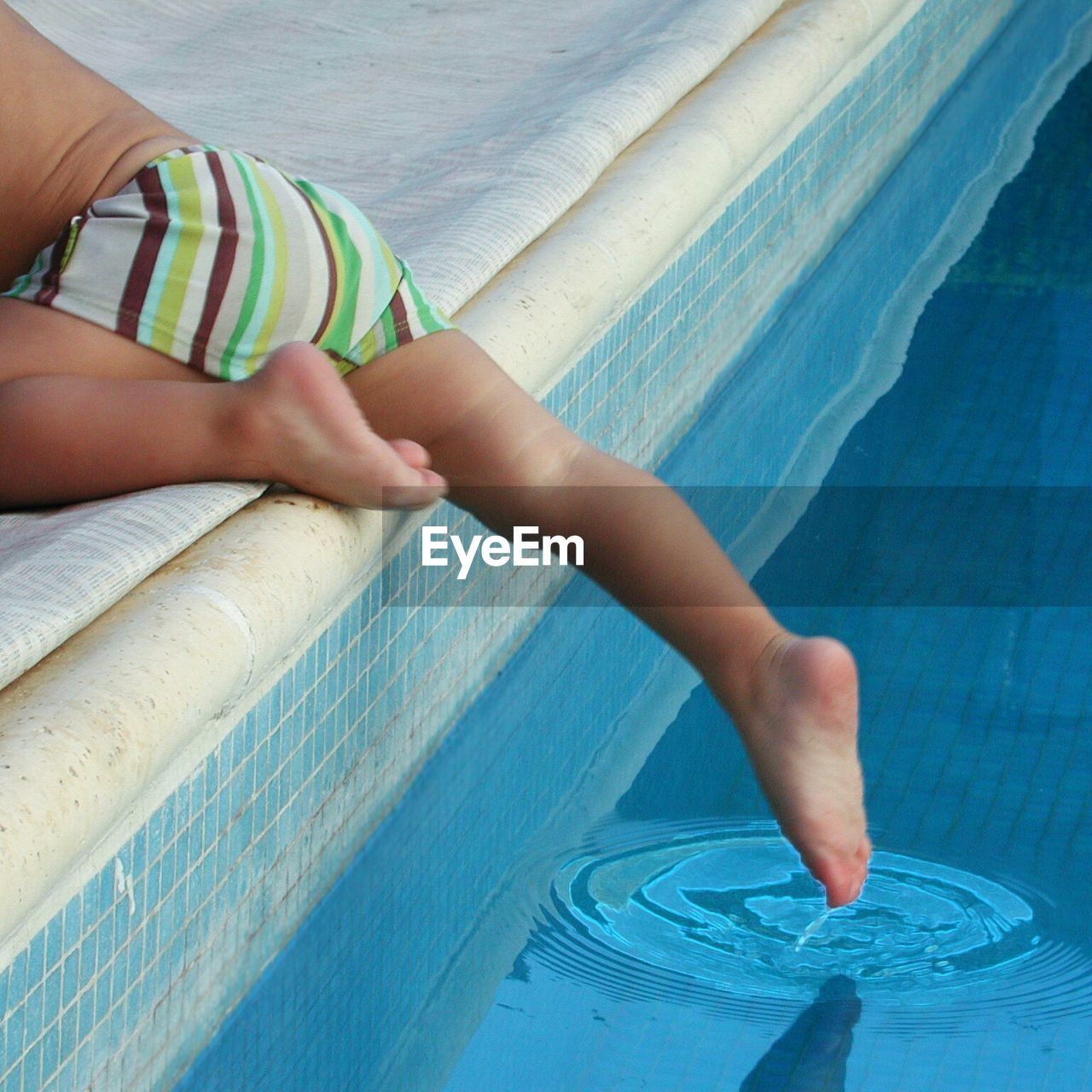 Low section of shirtless on poolside