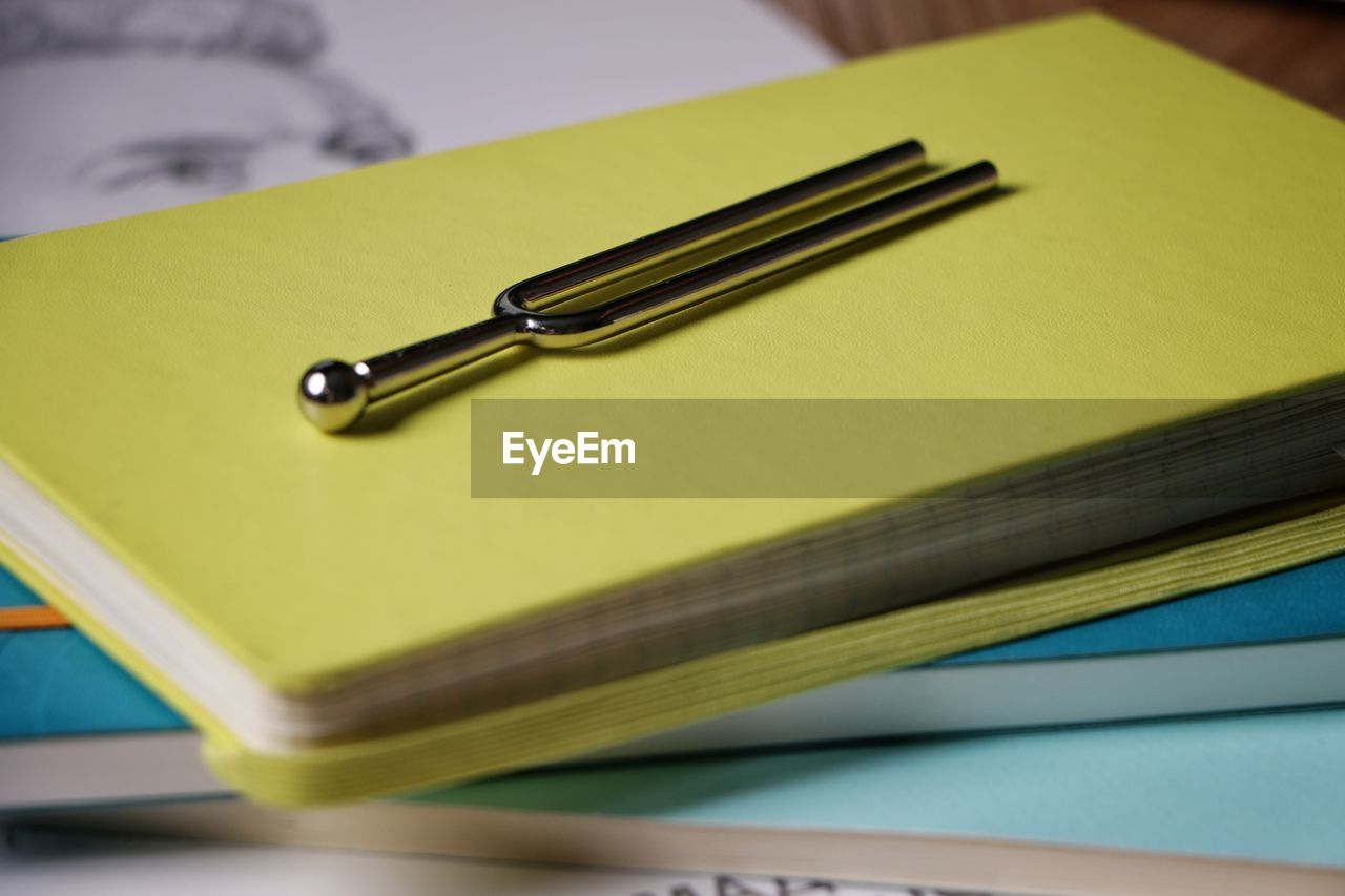 Close-up of tuning fork on notebook