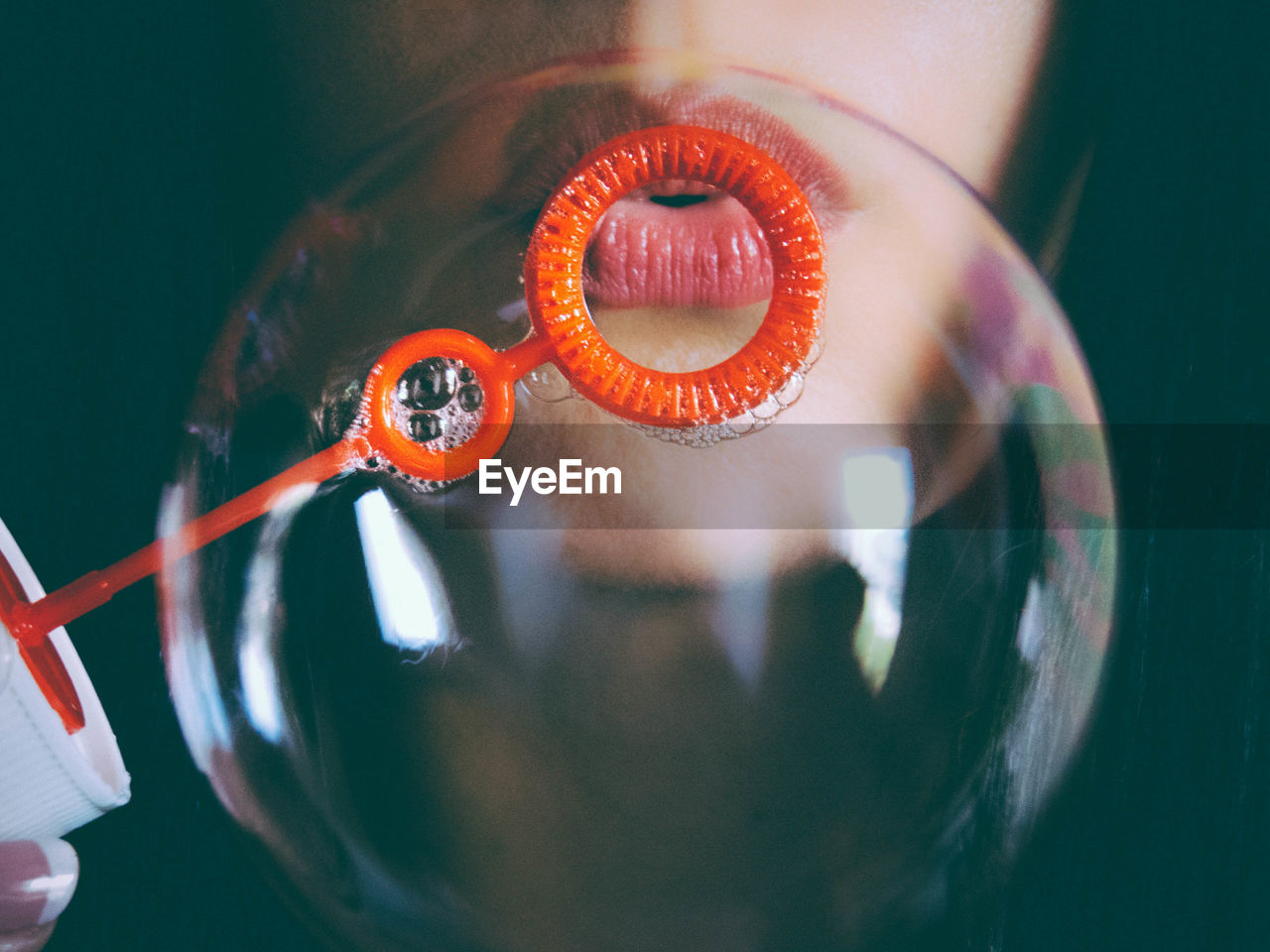 Close-up of woman blowing bubbles