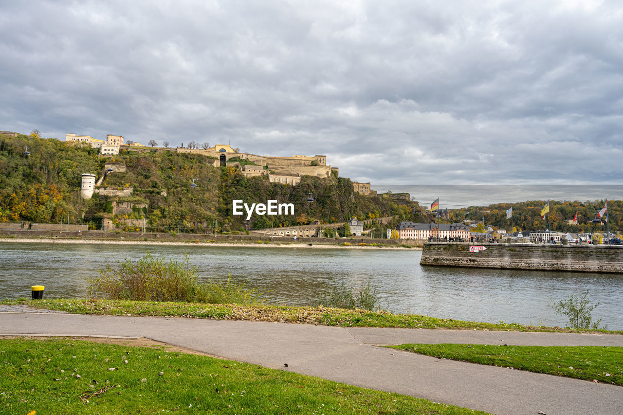 RIVER AMIDST CITY AGAINST SKY