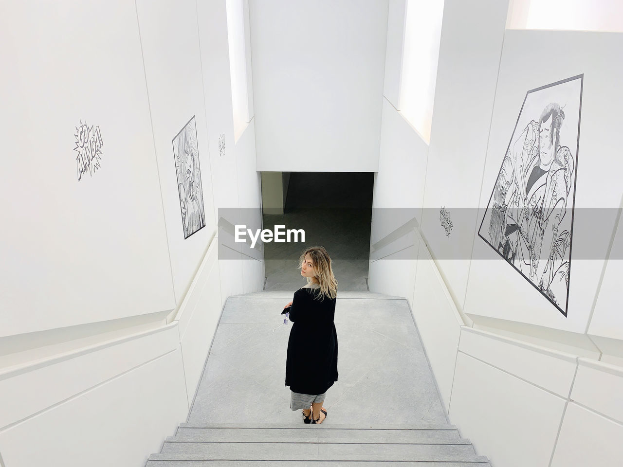 WOMAN STANDING IN MUSEUM