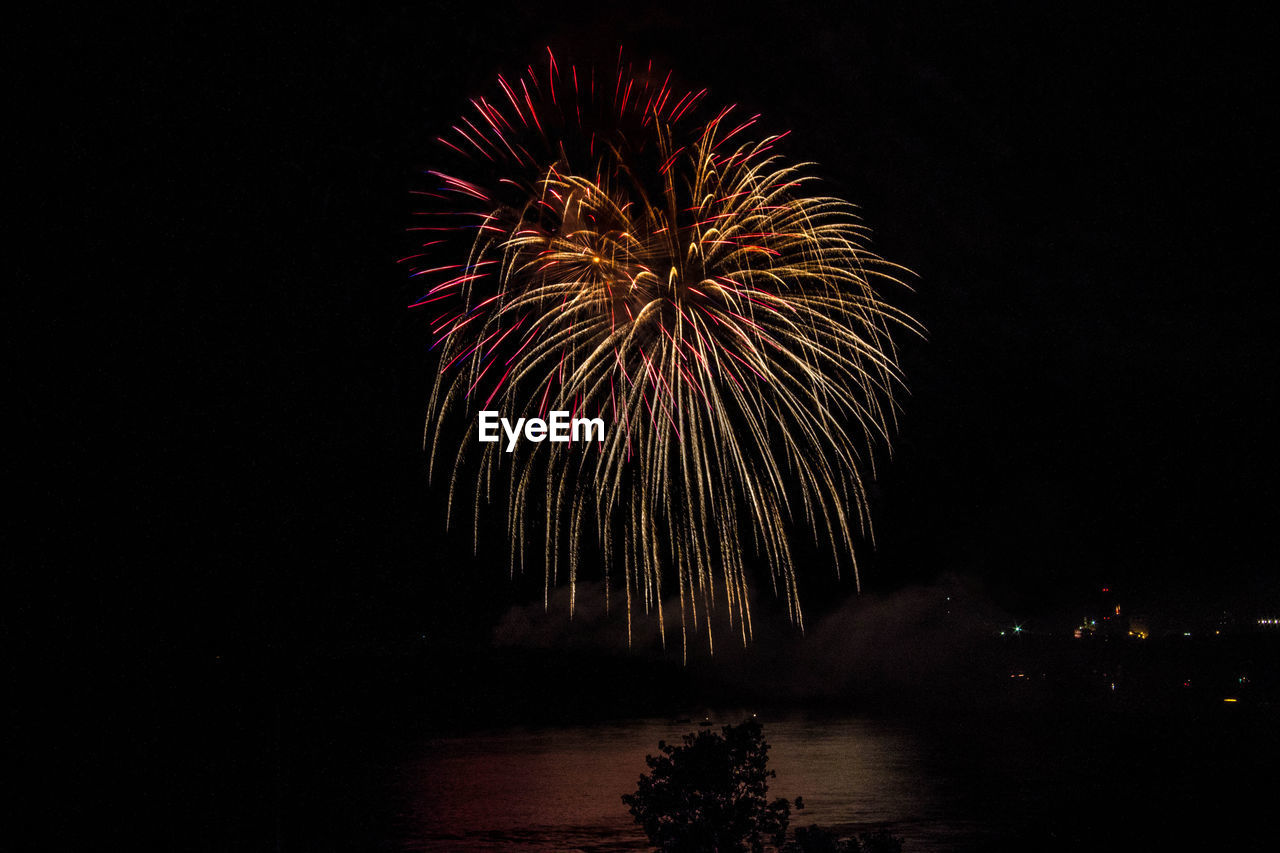 Firework exploding over mississippi river against sky