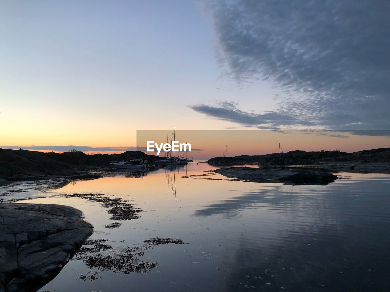 SCENIC VIEW OF BAY AGAINST SKY DURING SUNSET