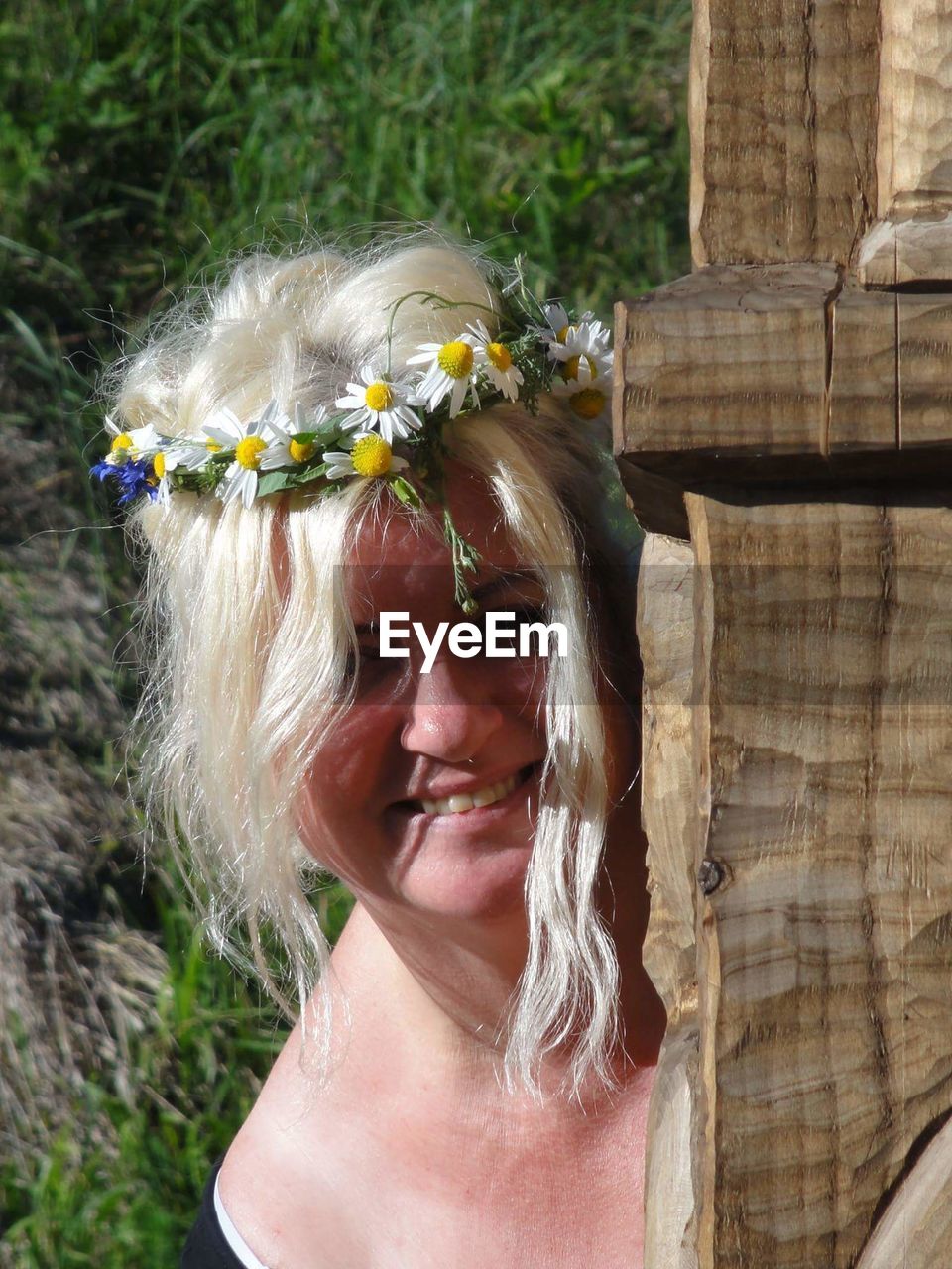 Portrait of smiling woman with flower tiara during sunny day