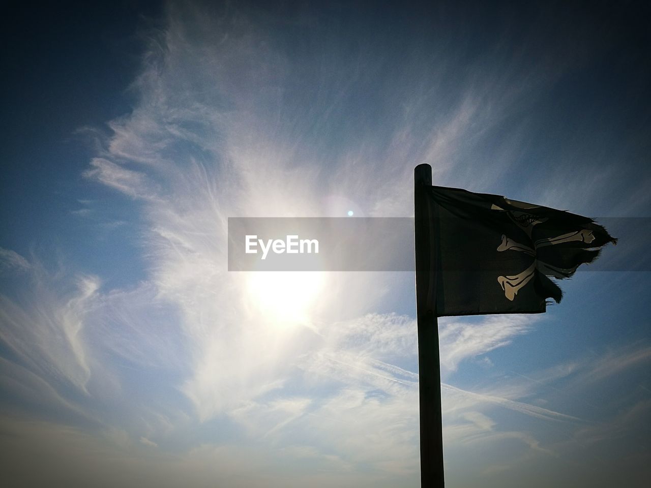 Low angle view of pirate flag against sky