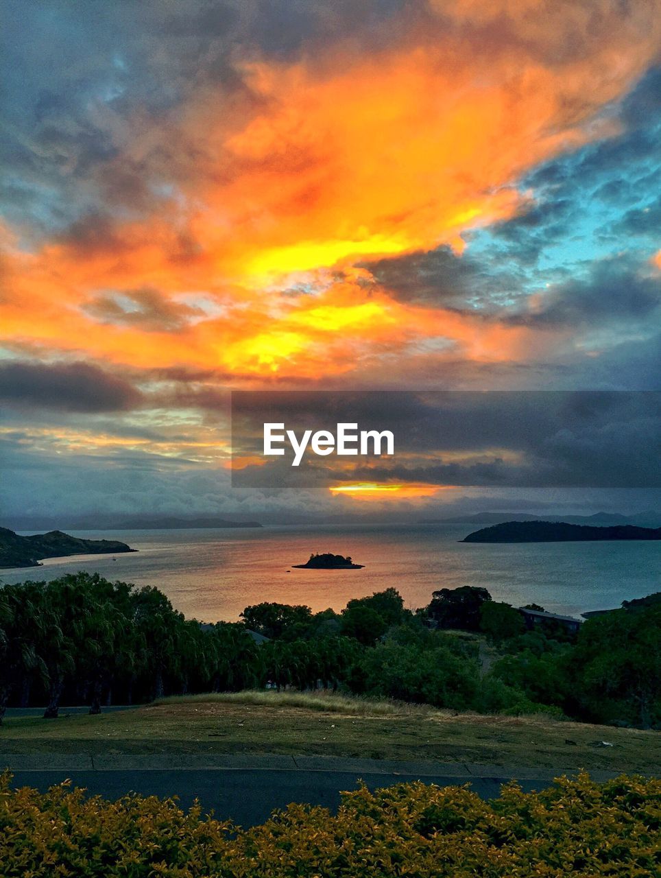 Scenic view of calm sea against cloudy sky during sunset