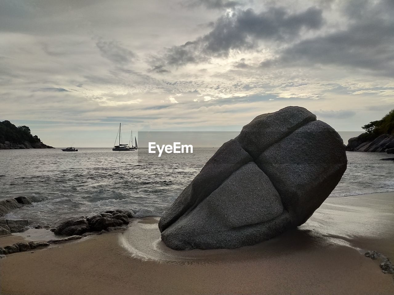 SAILBOAT ON SEA SHORE AGAINST SKY