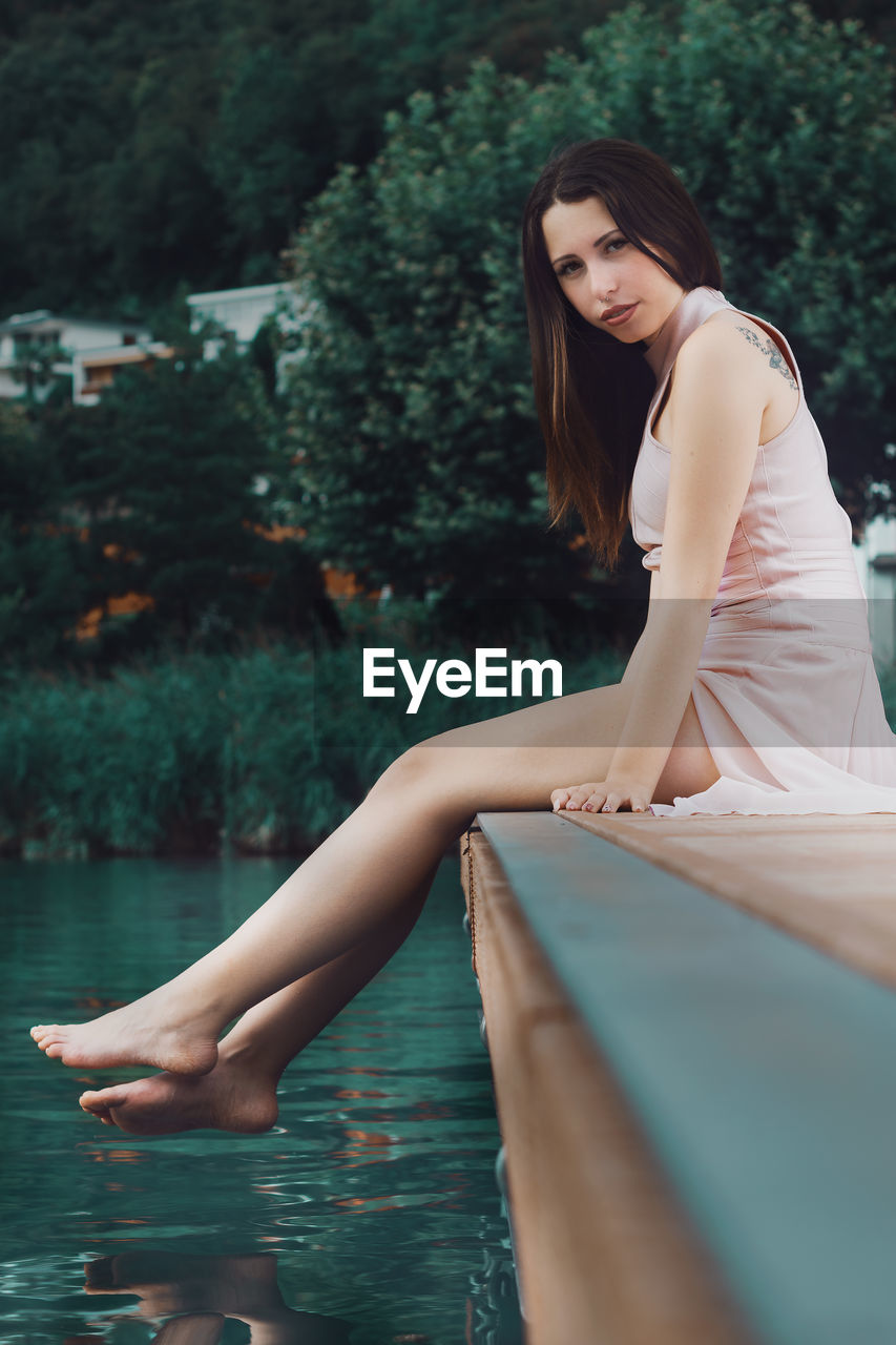 Portrait of woman sitting at poolside