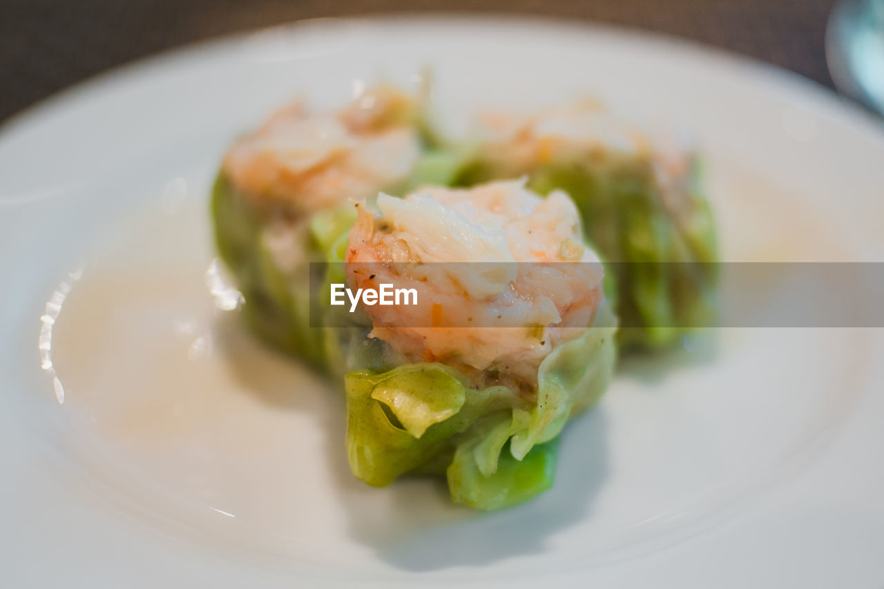 Close-up of fresh dim sum served in plate at restaurant