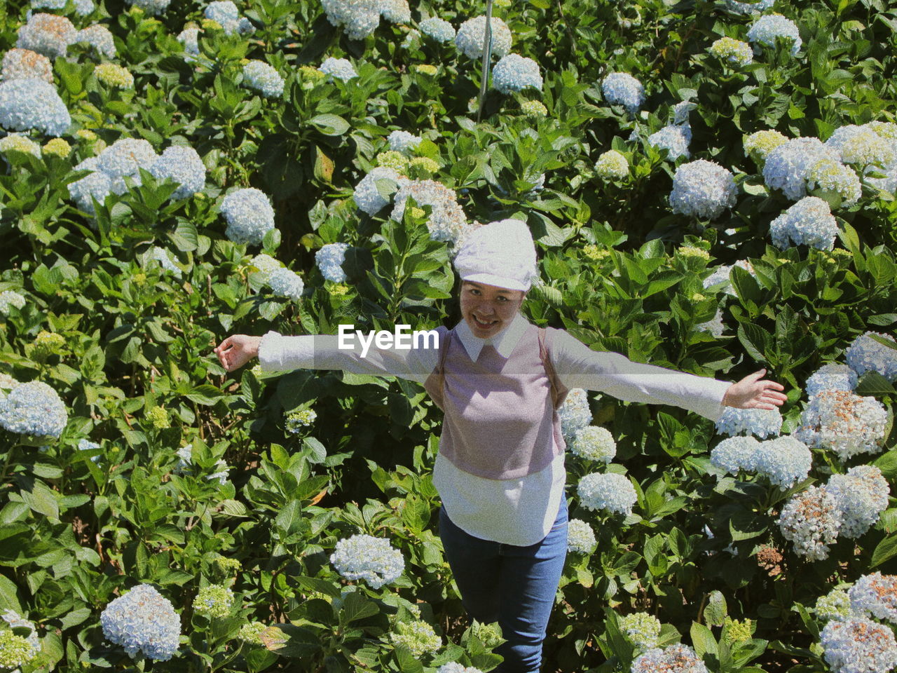 High angle portrait of woman standing amidst plants