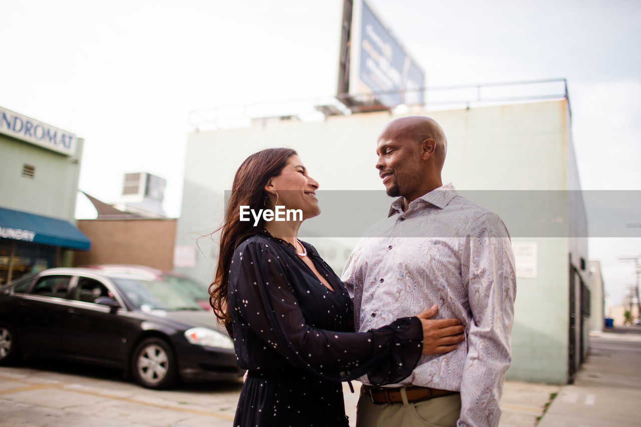 Late forties couple embracing in alley in san diego