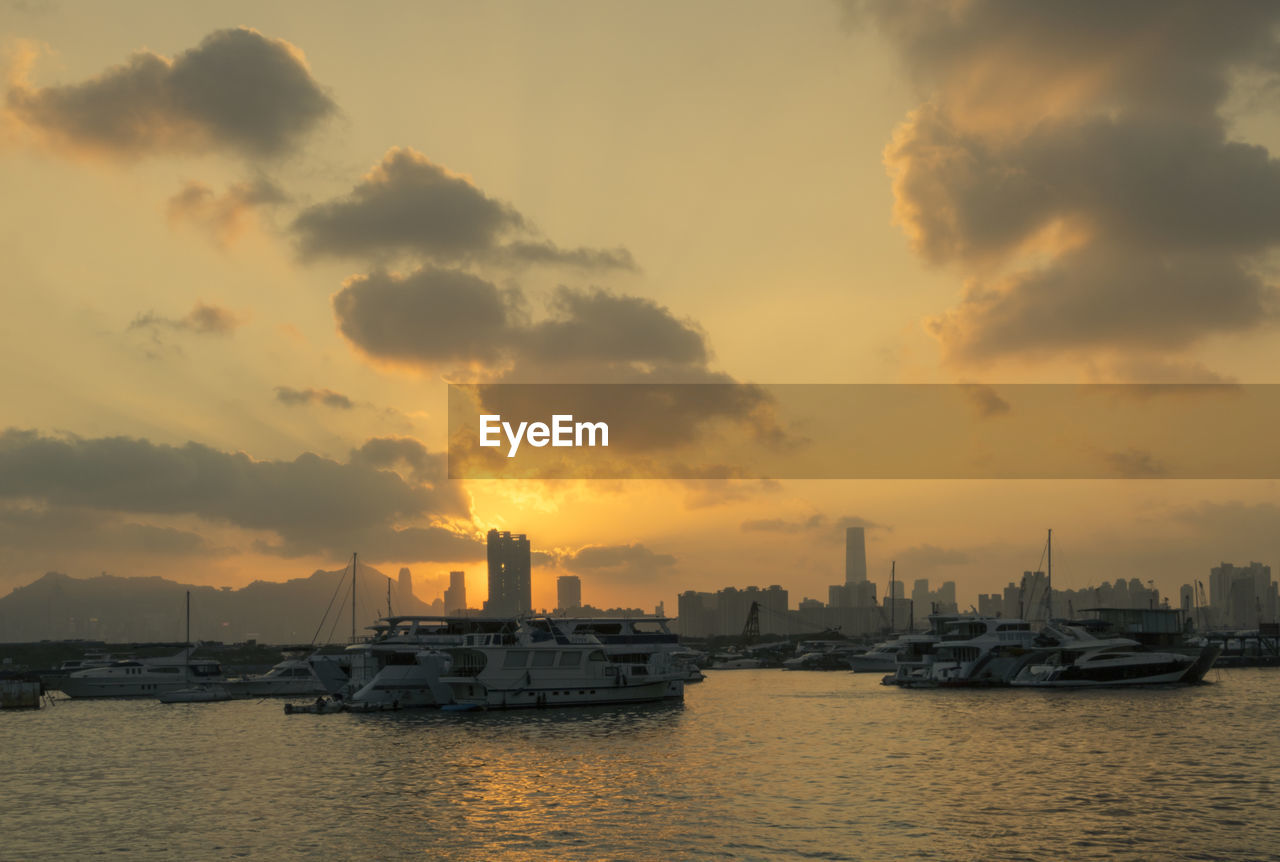 sky, water, cloud, architecture, sunset, horizon, building exterior, dawn, transportation, built structure, city, nautical vessel, ship, evening, sea, nature, skyline, harbor, industry, building, reflection, vehicle, bay, cityscape, mode of transportation, urban skyline, landscape, no people, environment, outdoors, afterglow, beauty in nature, business, travel destinations, office building exterior, watercraft, skyscraper, dramatic sky, boat, sunlight, business finance and industry, travel