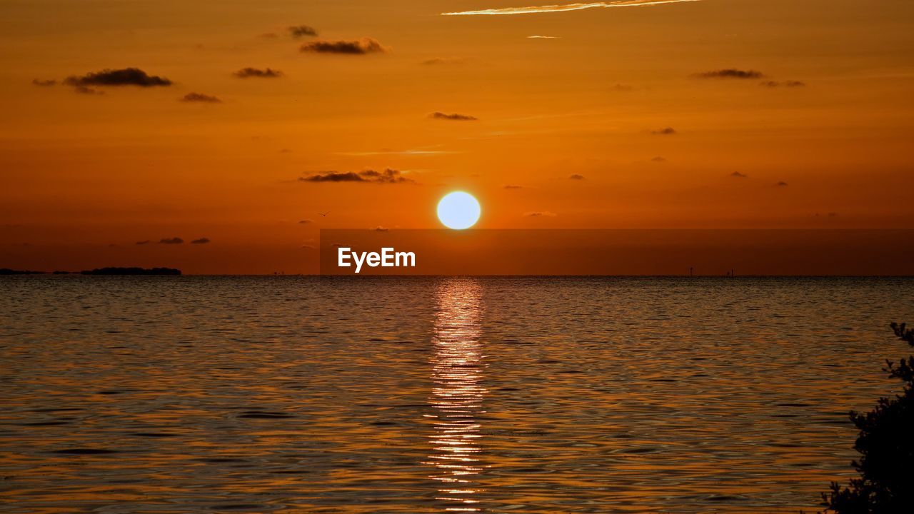 Scenic view of sea against orange sky