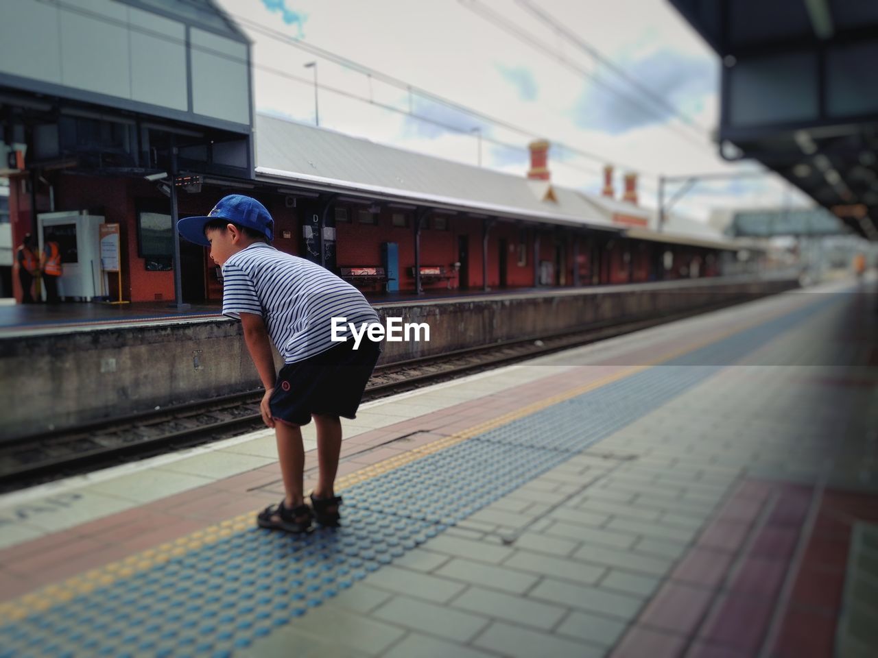Full length of boy standing at railroad station platform