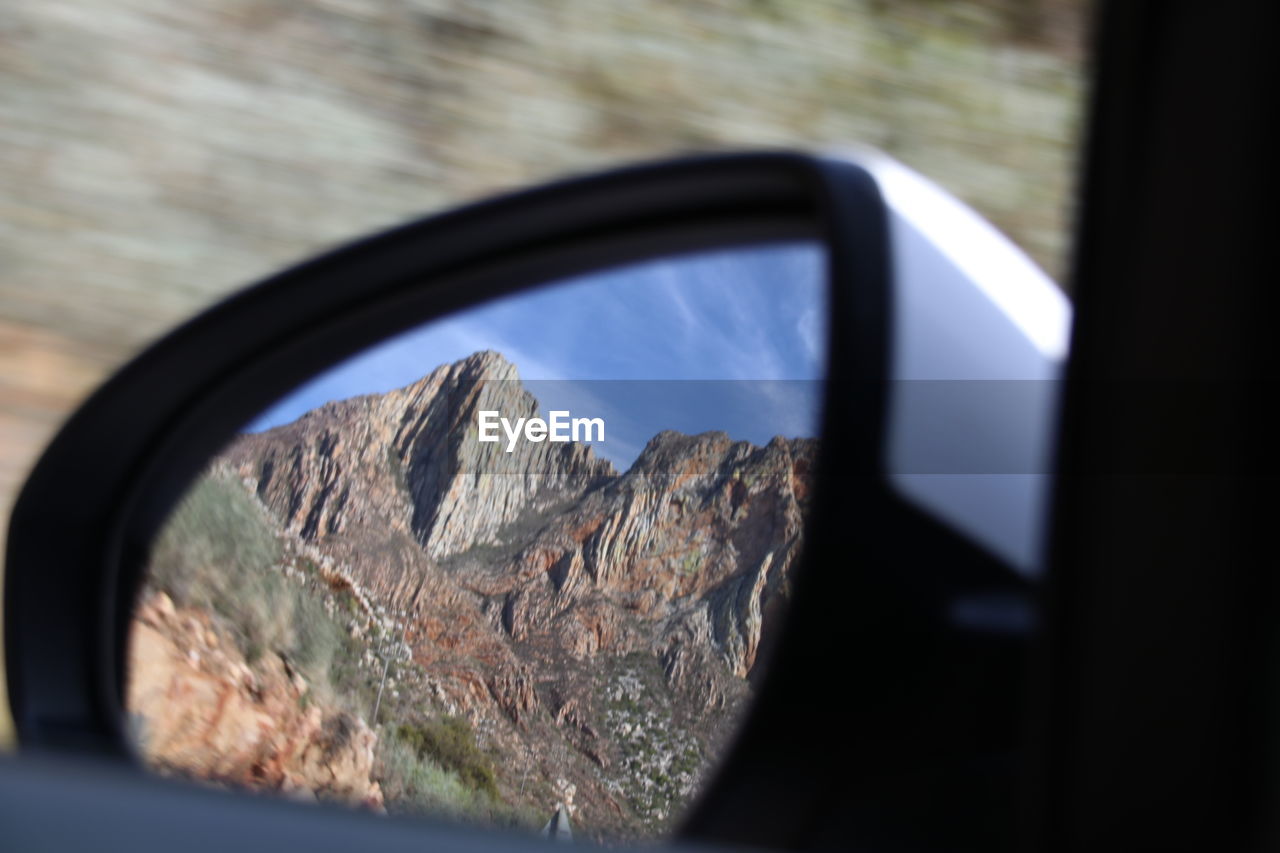 Reflection of mountain on side-view mirror