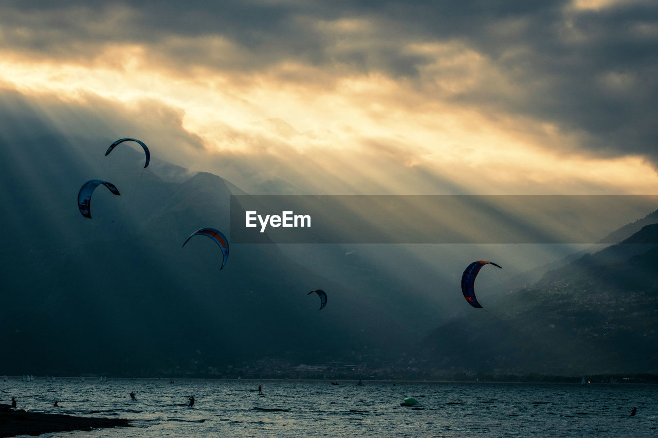 PEOPLE ENJOYING IN SEA AGAINST SKY
