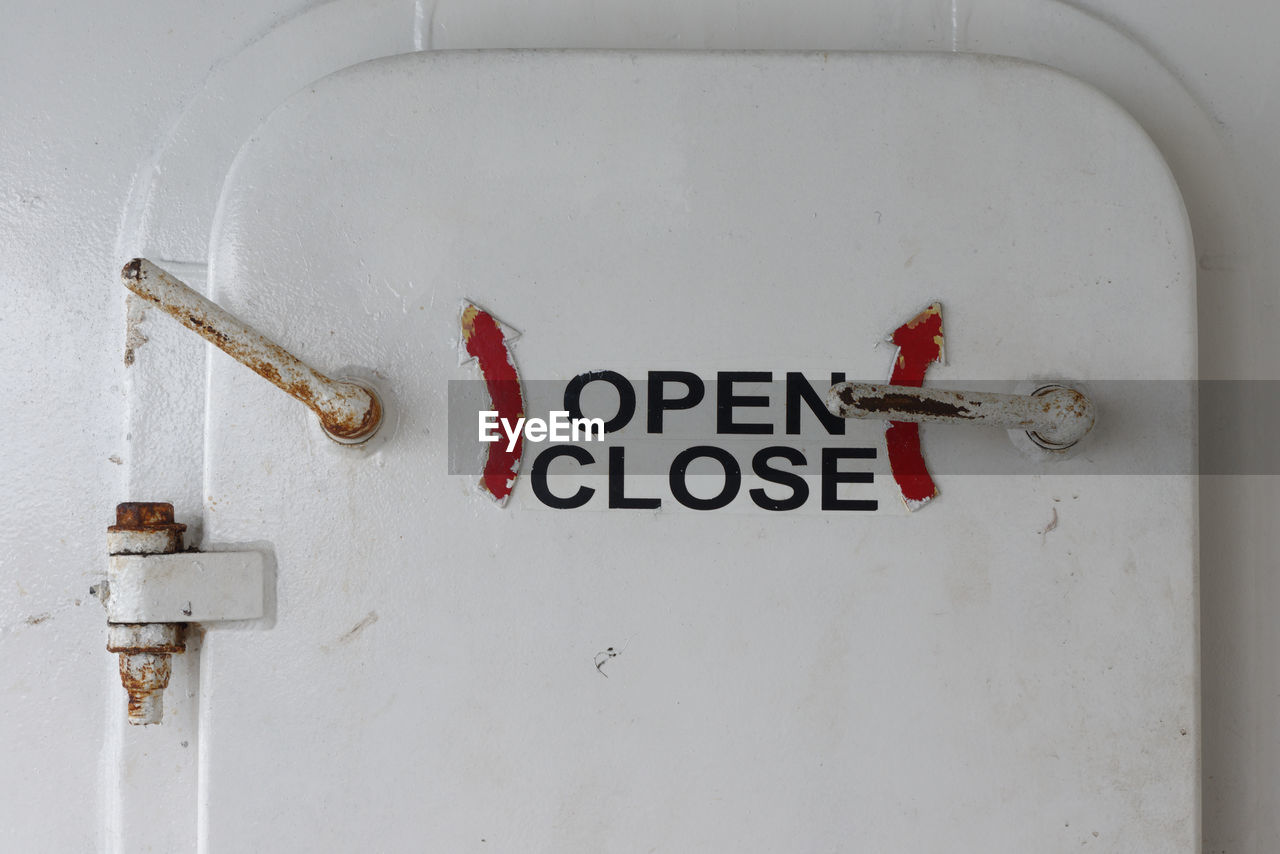 Close-up of ship door with open and close sign