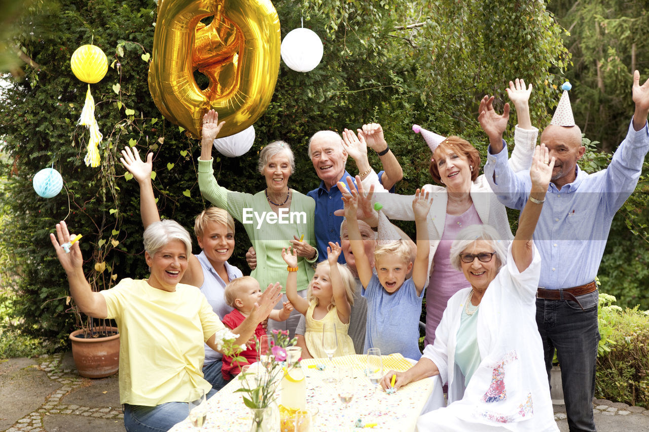 Extended family and friends having birthday party in garden