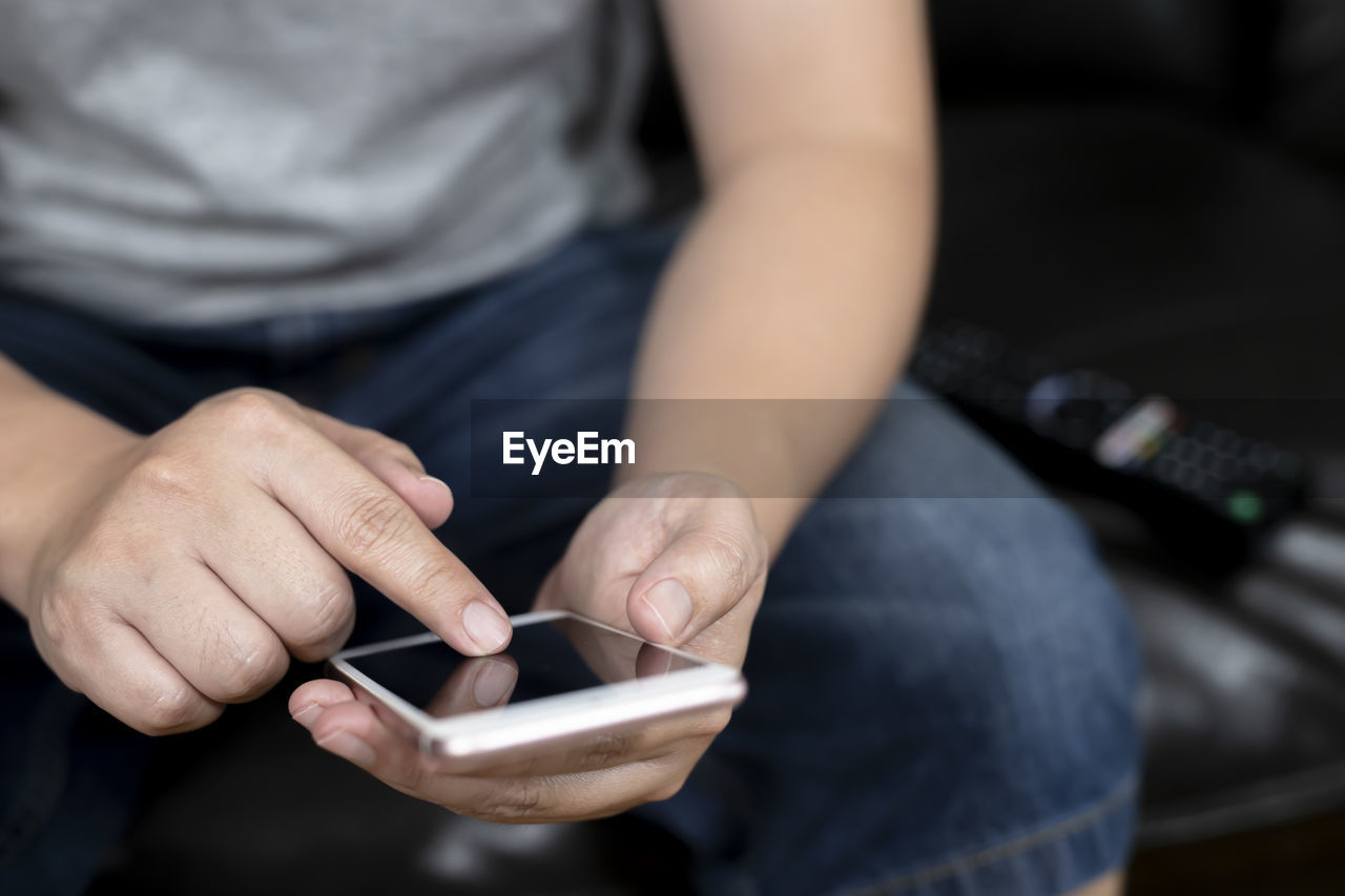 Midsection of man using mobile phone