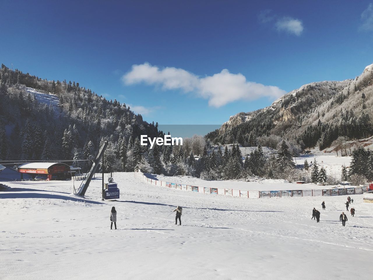 GROUP OF PEOPLE ON SNOW COVERED LAND AGAINST SKY