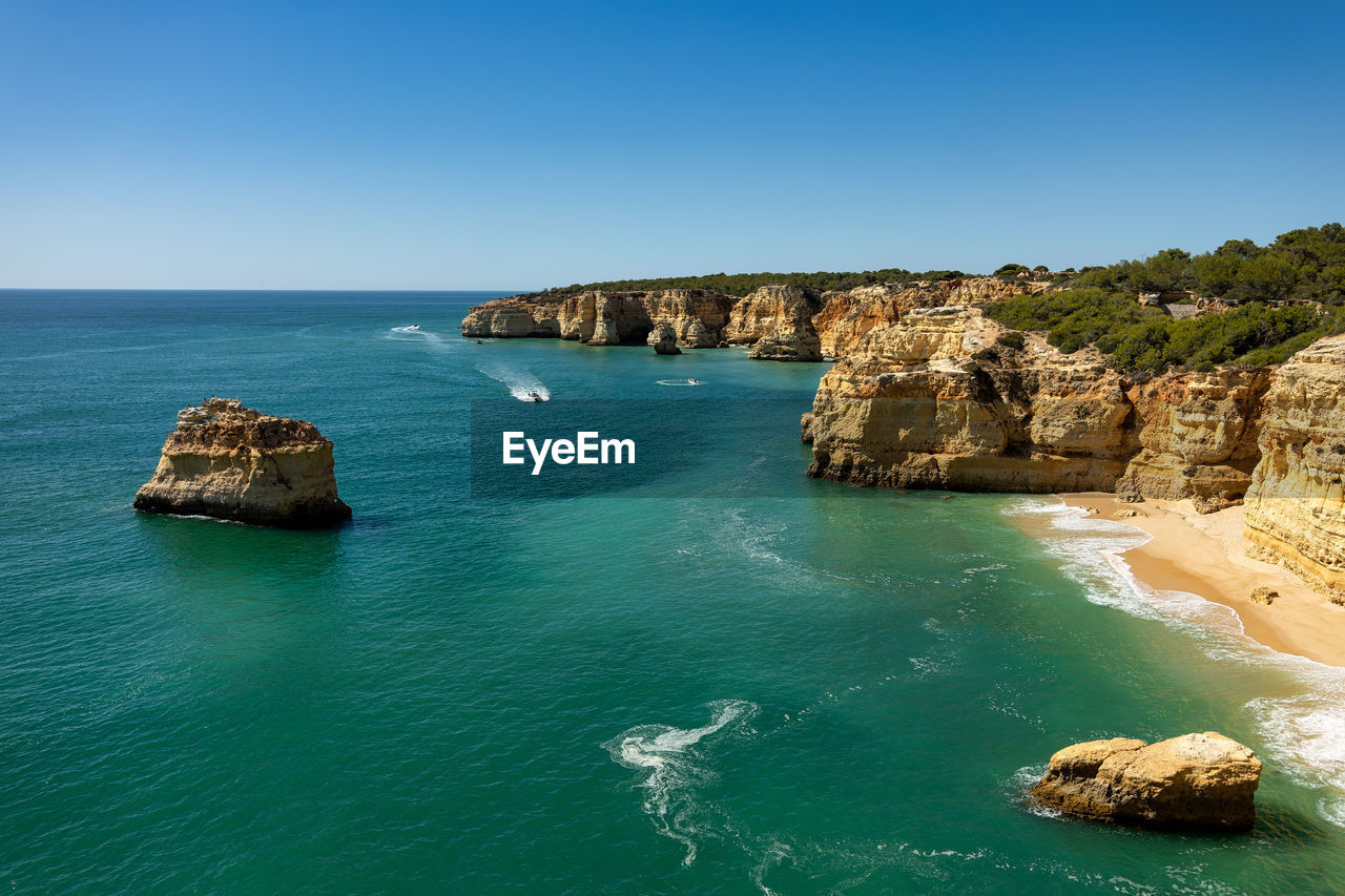 Scenic view of sea against clear blue sky