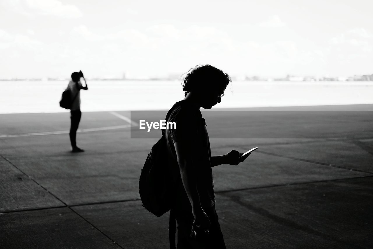 Side view of man using mobile phone at tempelhof airport