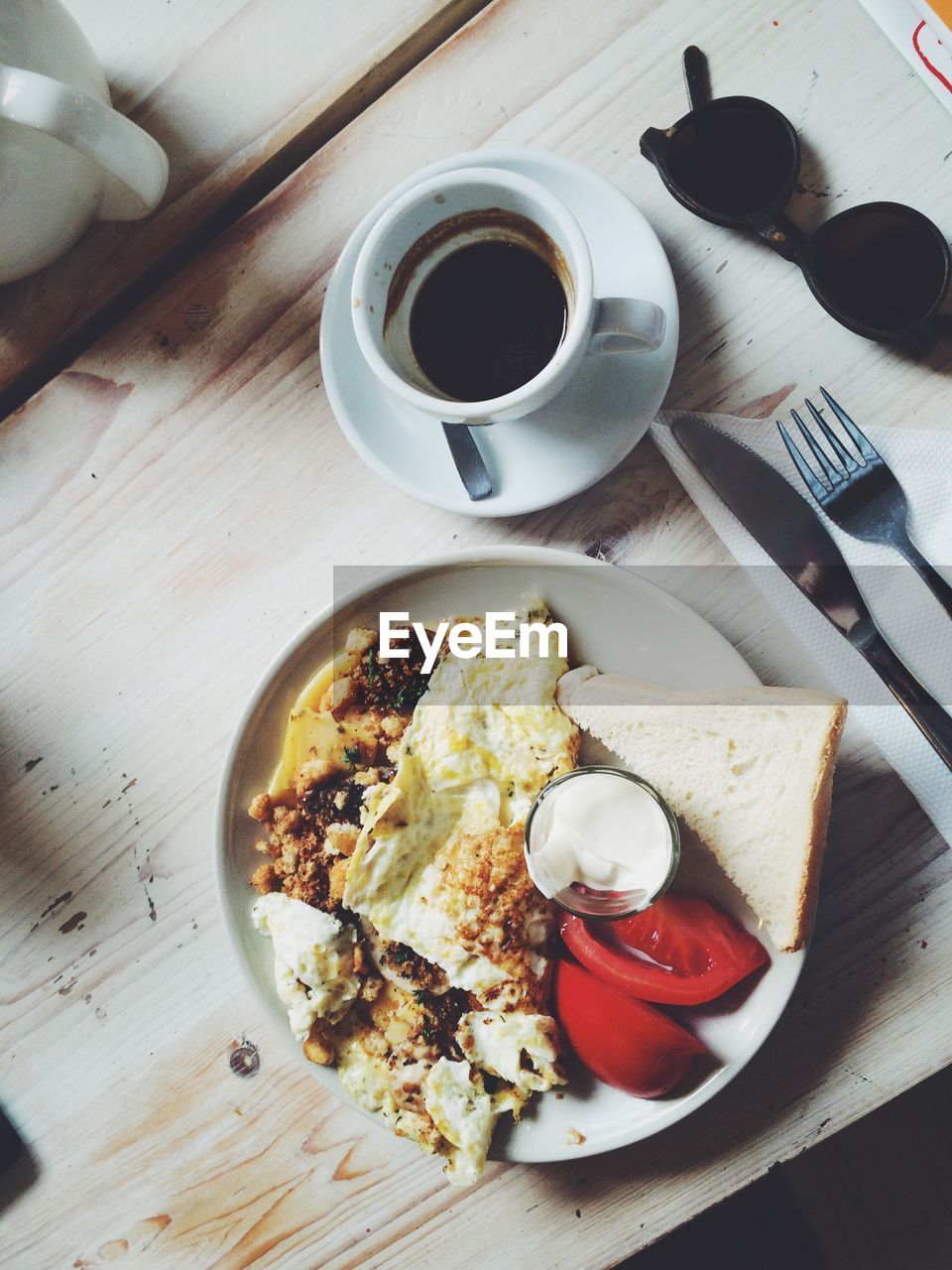 High angle view of breakfast served in plate by coffee cup on table