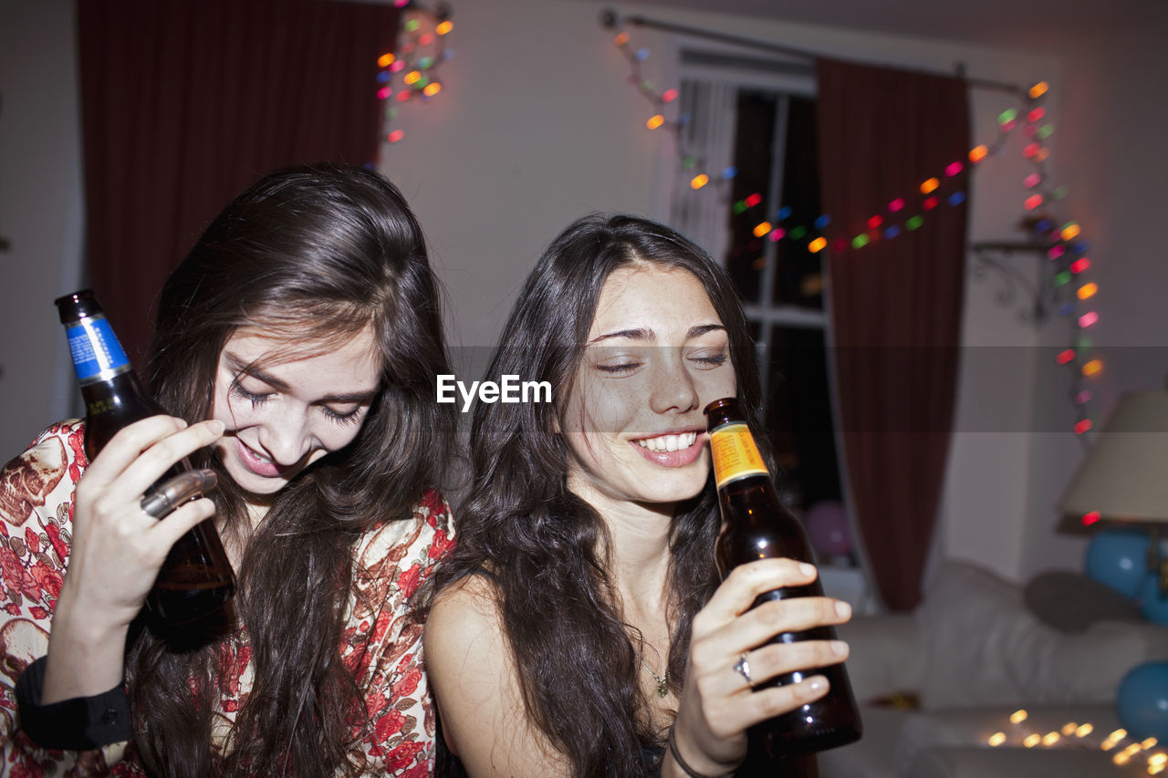 Young women drinking beer from bottles