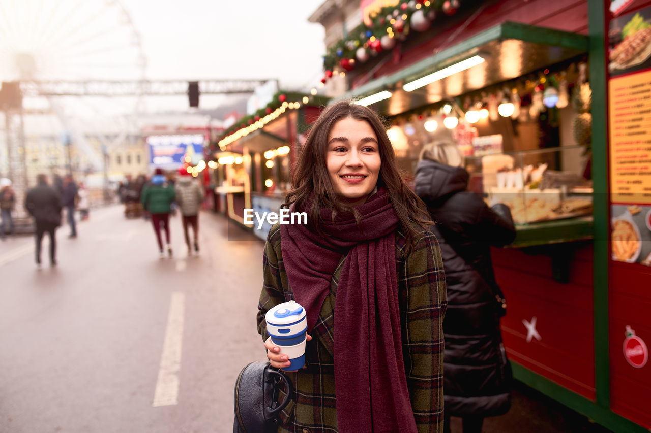 Pretty woman holding reusable coffee cup