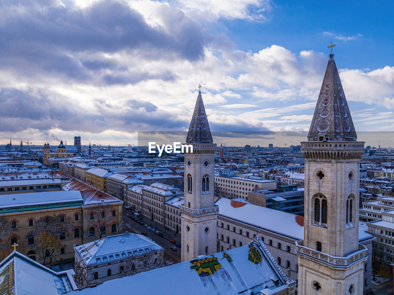 buildings in city against cloudy sky