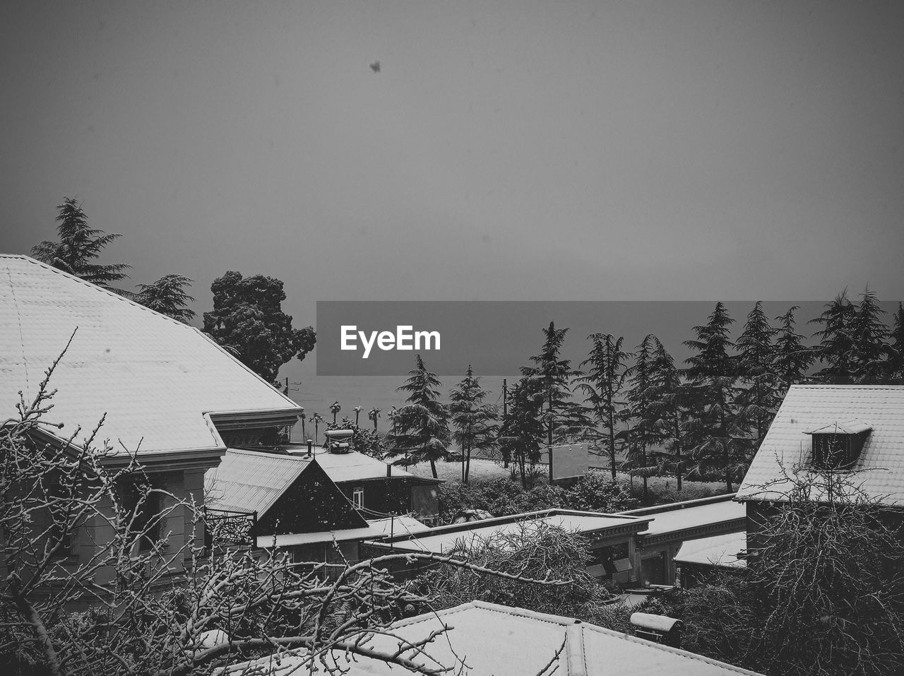 High angle view of houses and trees against sky during winter