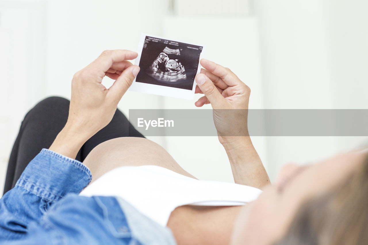 Close-up of pregnant woman lying on bed