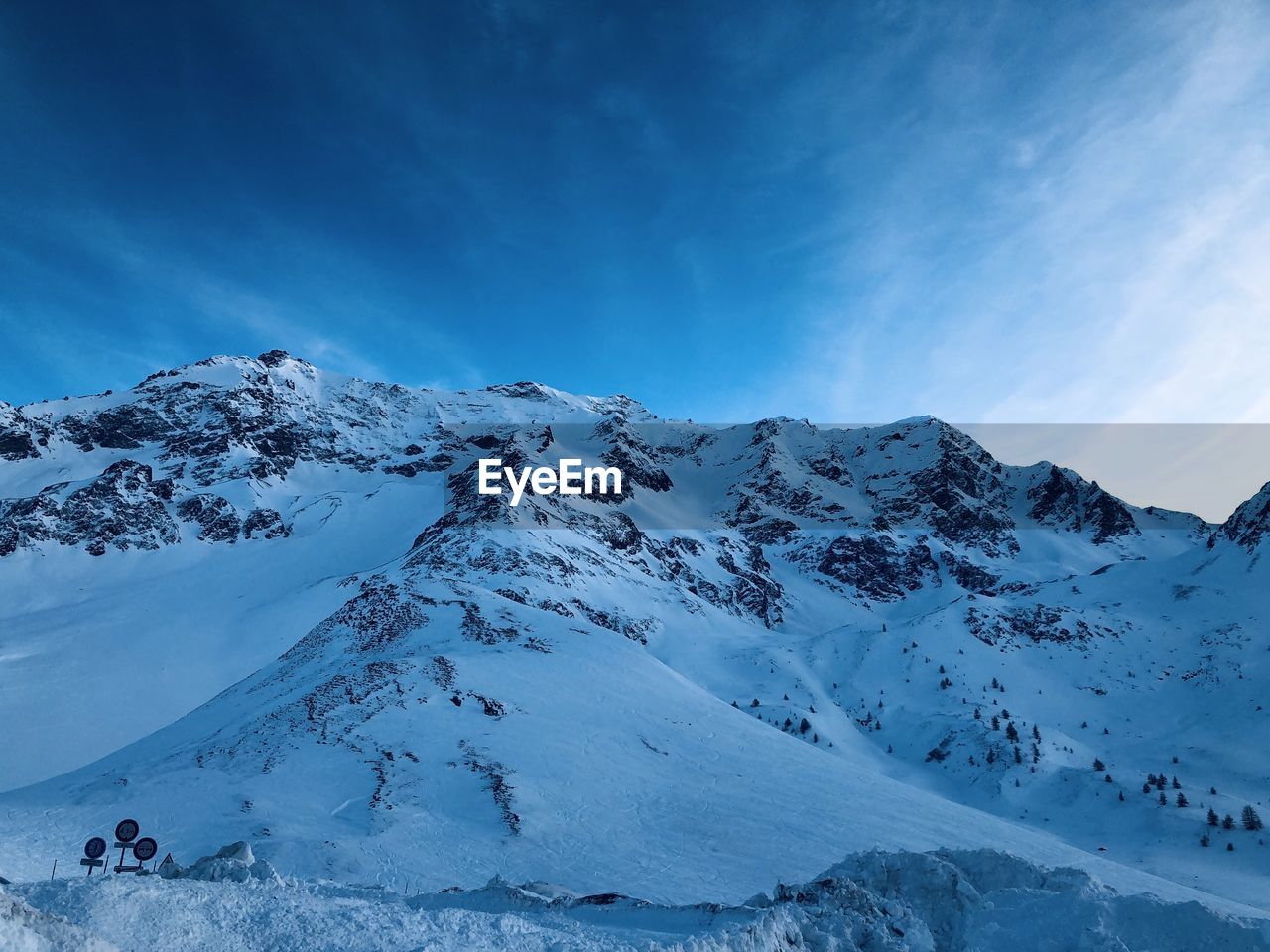 Scenic view of snowcapped mountains against blue sky