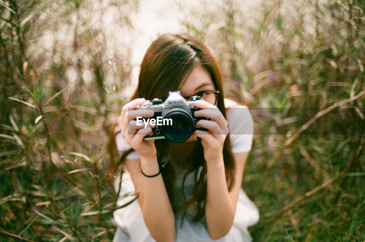 WOMAN PHOTOGRAPHING THROUGH CAMERA