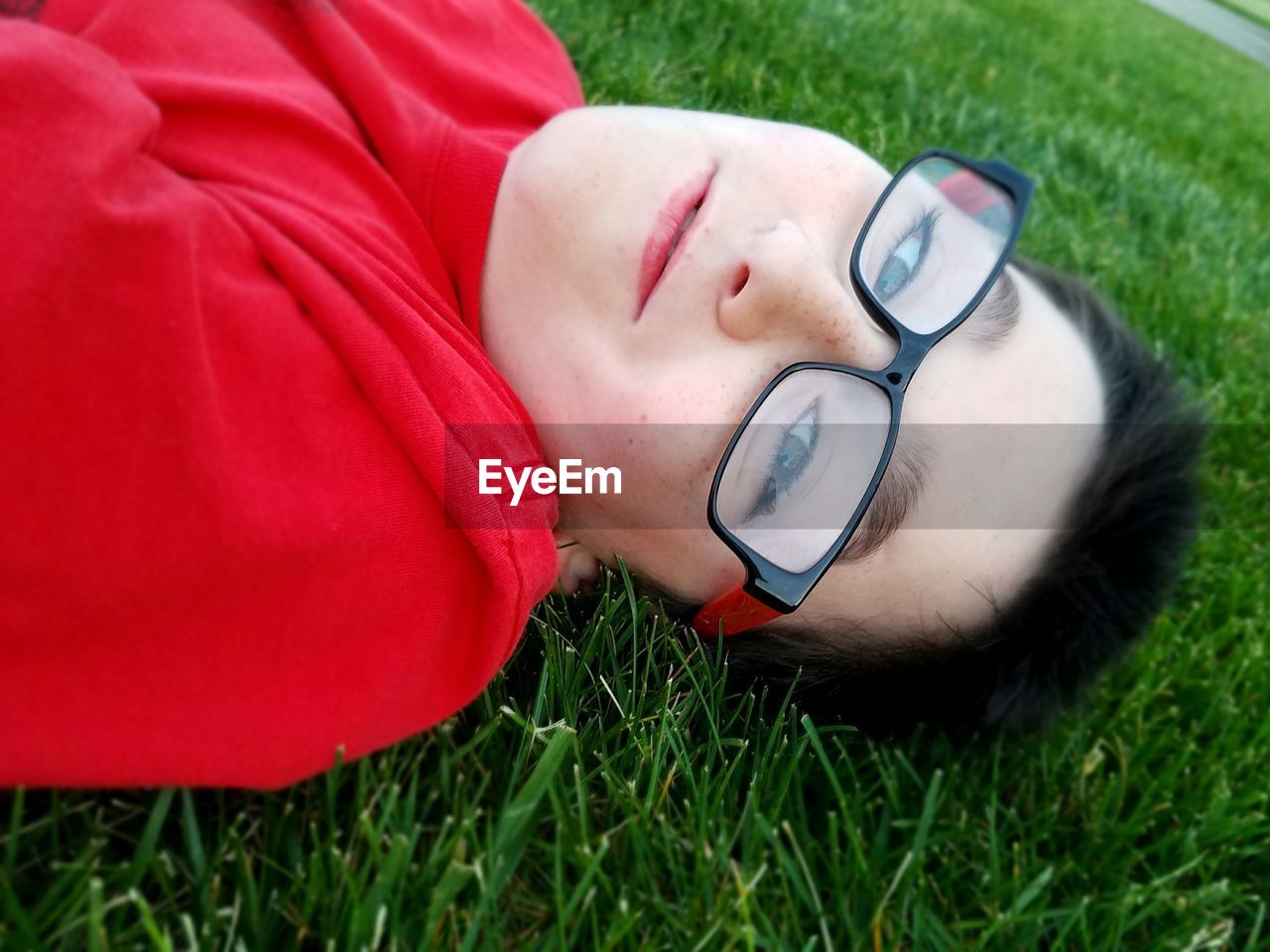 Portrait of boy lying on grassy field