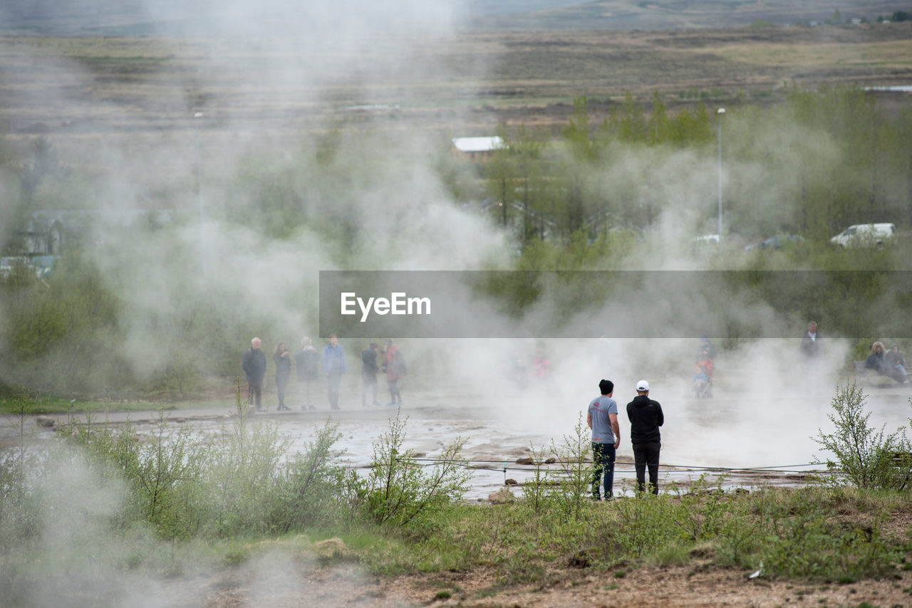 Tourists visiting and waiting for the eruption of strokkur geyser in the golden circle of iceland