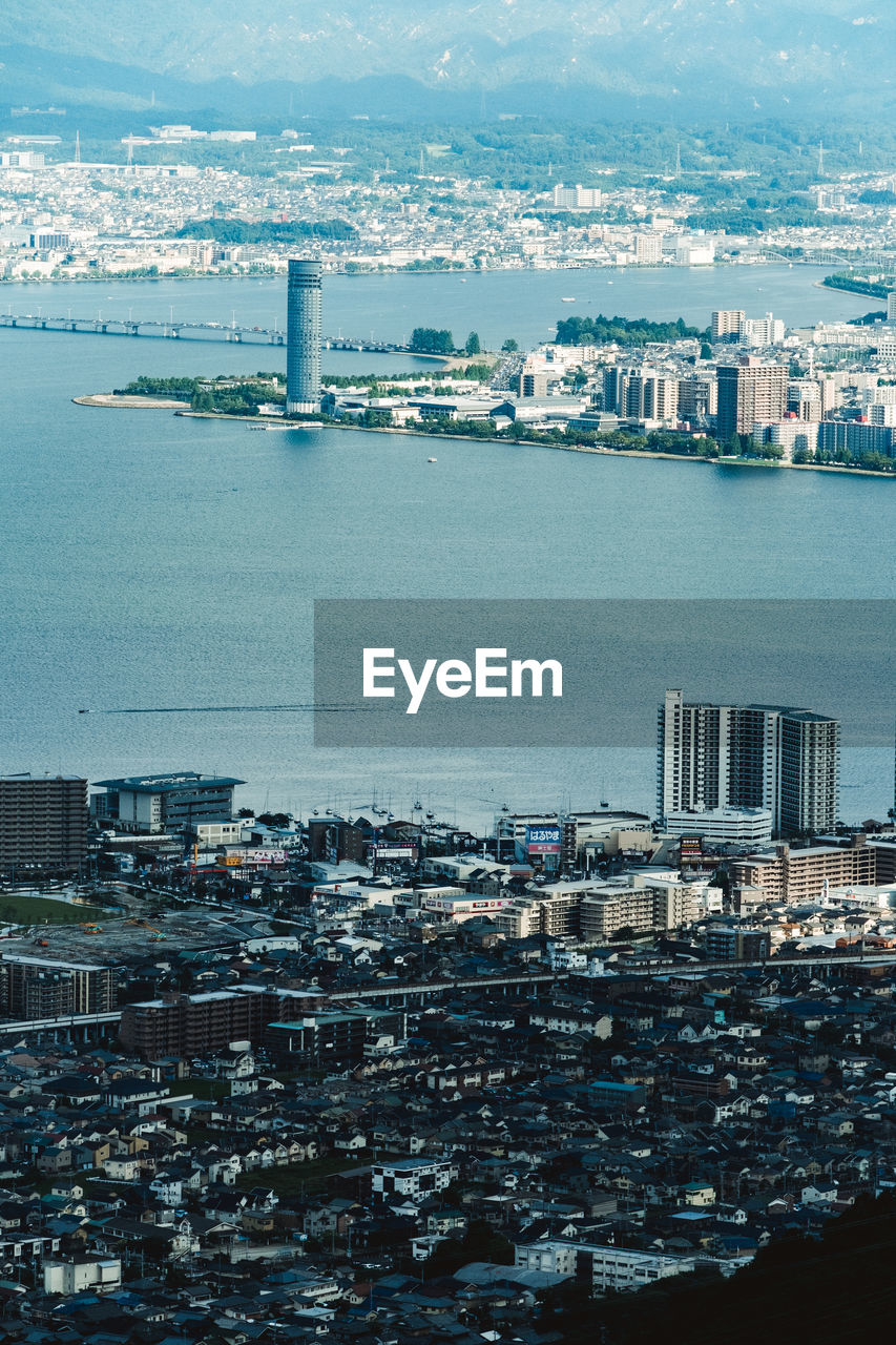 High angle view of buildings by sea against sky