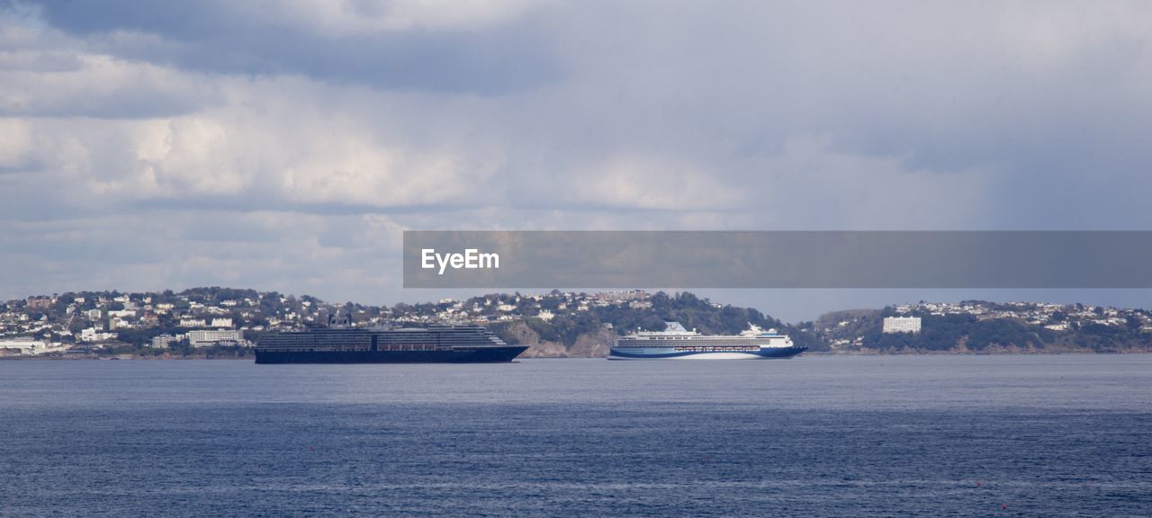 SCENIC VIEW OF SEA AGAINST BUILDINGS IN CITY