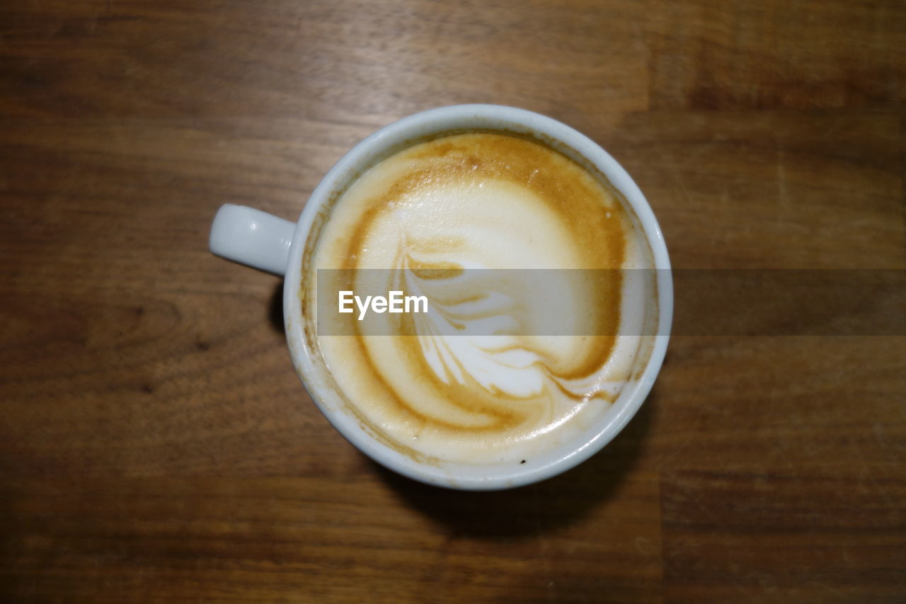 Directly above shot of coffee cup on wooden table