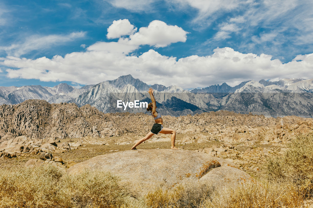 Young woman practicing yoga near alabama hills in northern california.