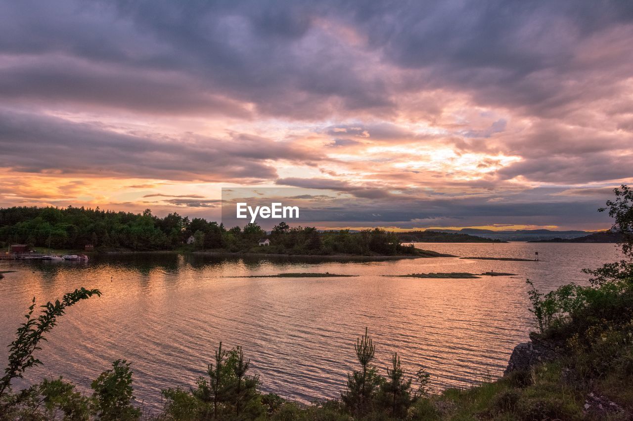 Scenic view of river against sky at sunset