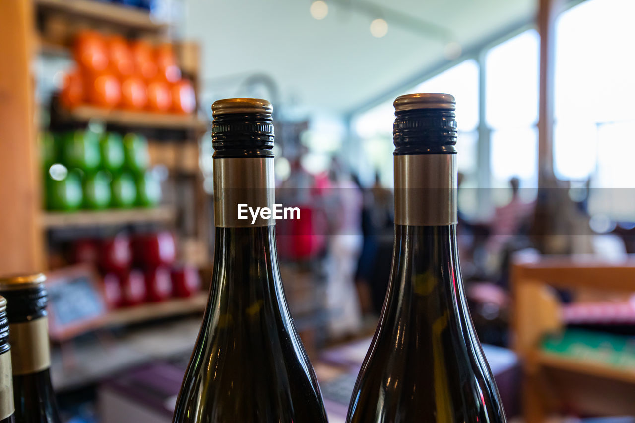 CLOSE-UP OF WINE BOTTLES IN GLASS