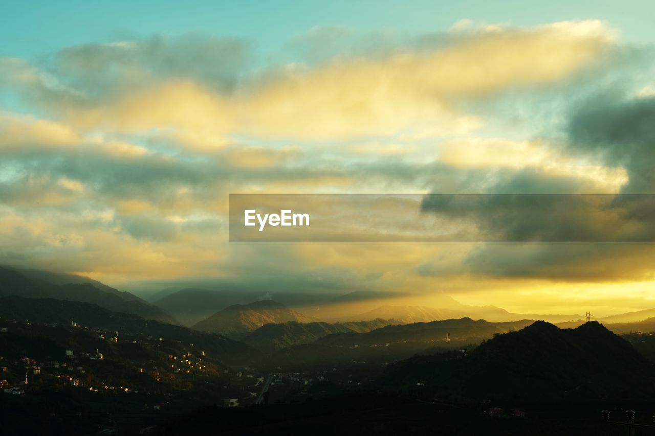 SCENIC VIEW OF MOUNTAINS AGAINST SUNSET SKY