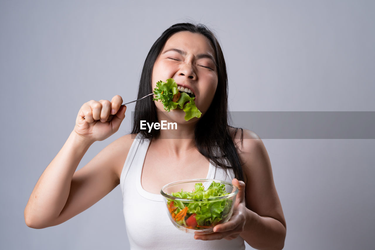 YOUNG WOMAN EATING FOOD