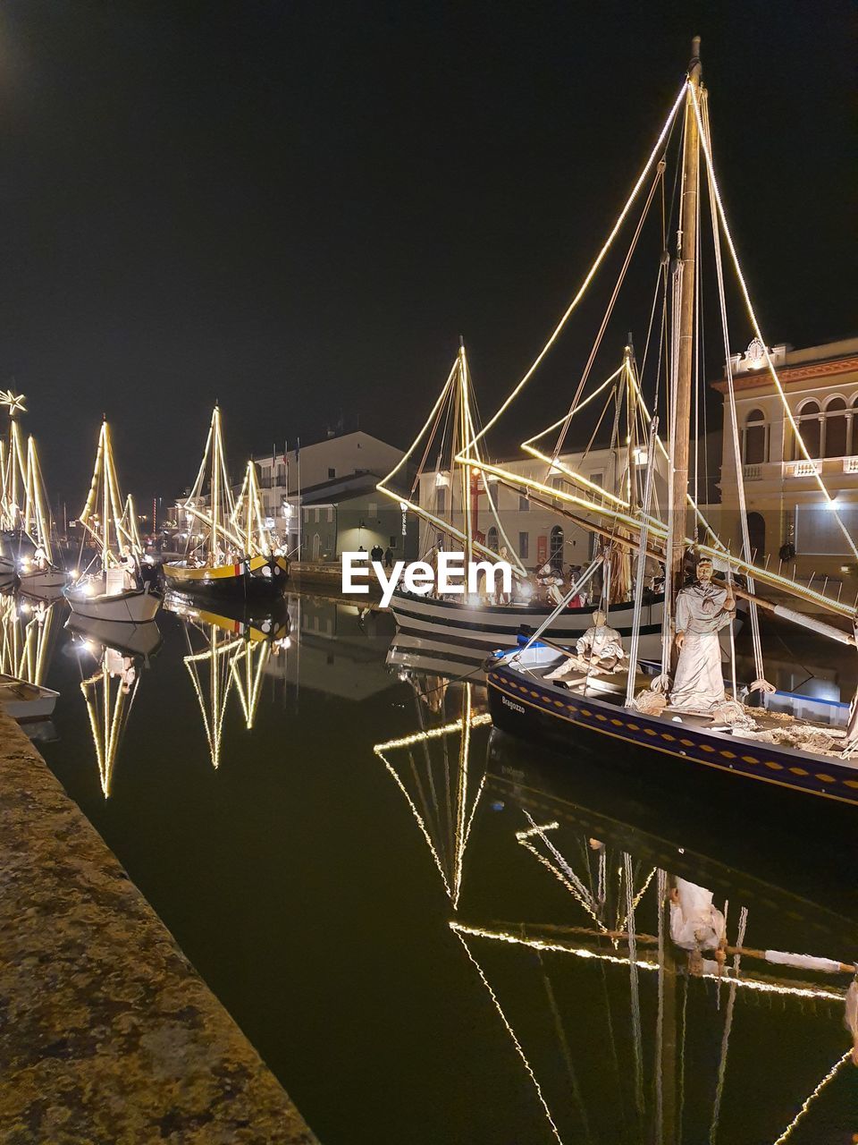 Sailboats moored at harbor