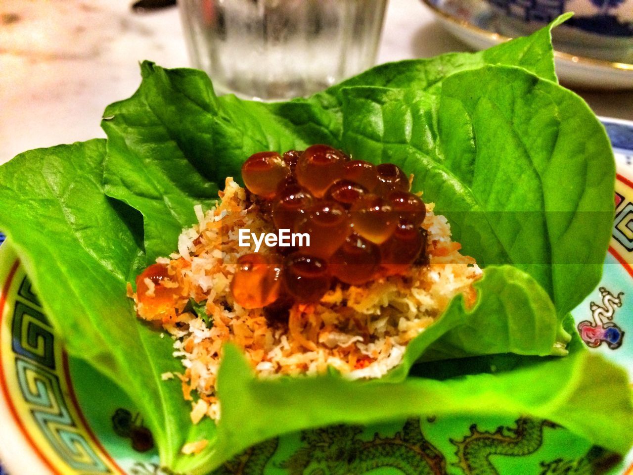 Close-up of fish eggs and rice served with leaves in plate