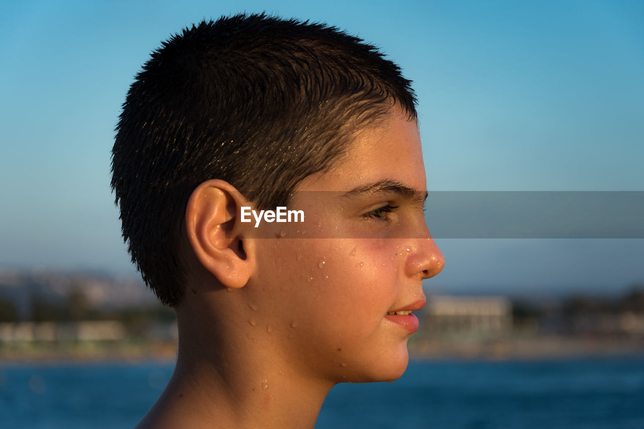 Portrait of shirtless boy against clear sky