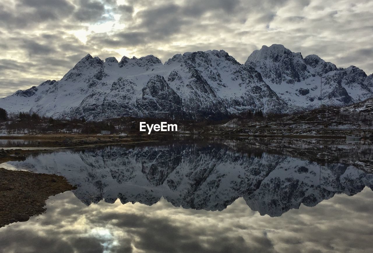 Scenic view of lake and snowcapped mountains against sky